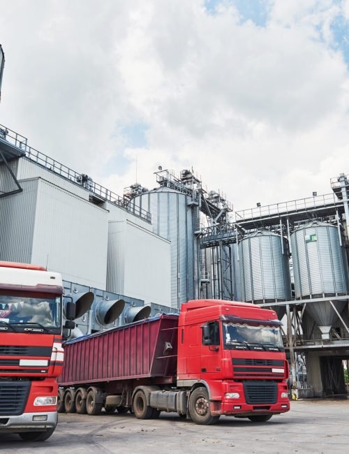 Agricultural Silo – Building Exterior, Storage and drying of grains, wheat, corn, soy Agricultural Silo - Building Exterior, Storage and drying of grains, wheat, corn, soy, sunflower and two trucks waiting